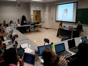 A student discussion about a lecture in a college classroom.