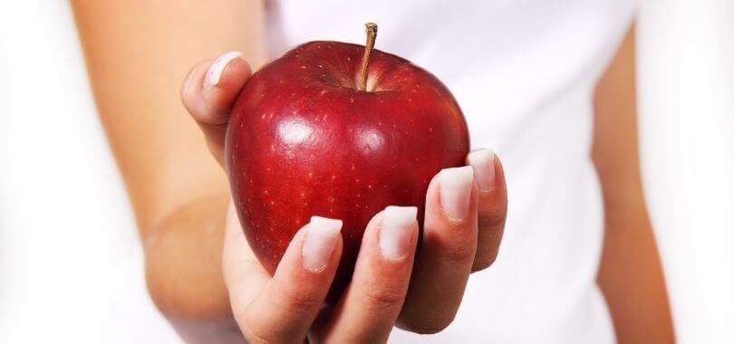 College student holding an apple